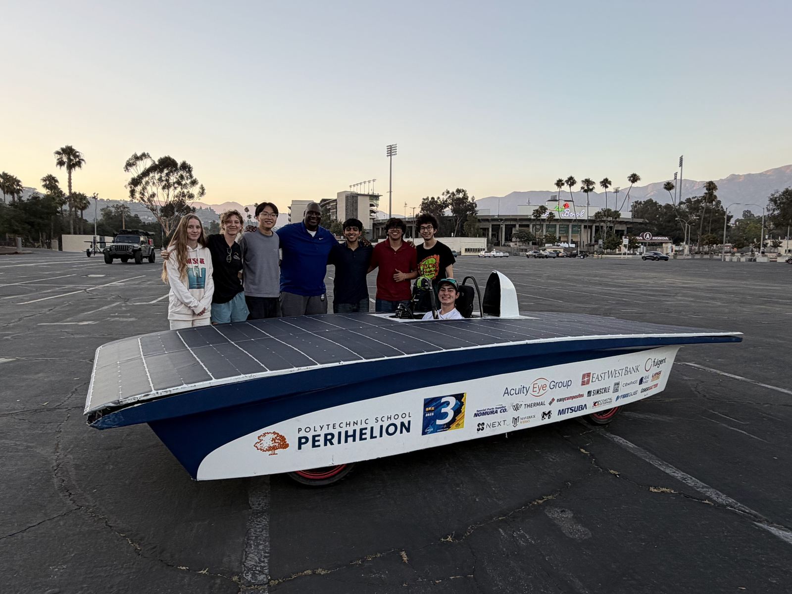 The Perihelion solar car with the team at a test session